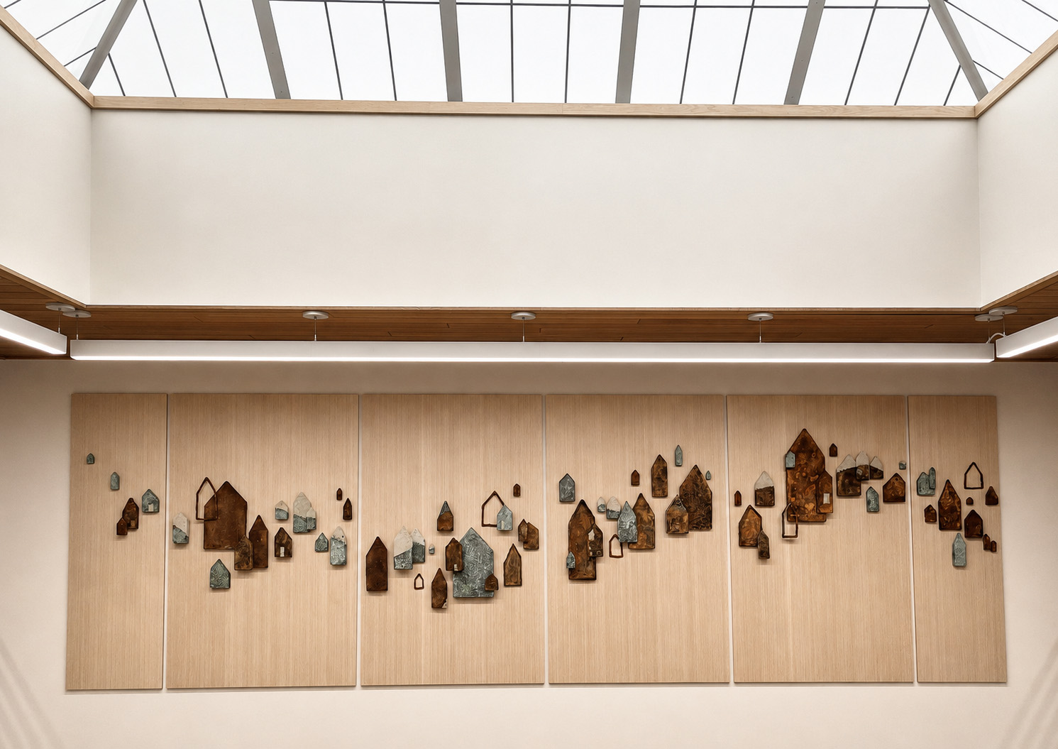 Jennifer Alden, Saints and Poets, Maybe — long horizontal procession of small ceramic and bronze house forms across oak panels in the Bozeman City Hall atrium