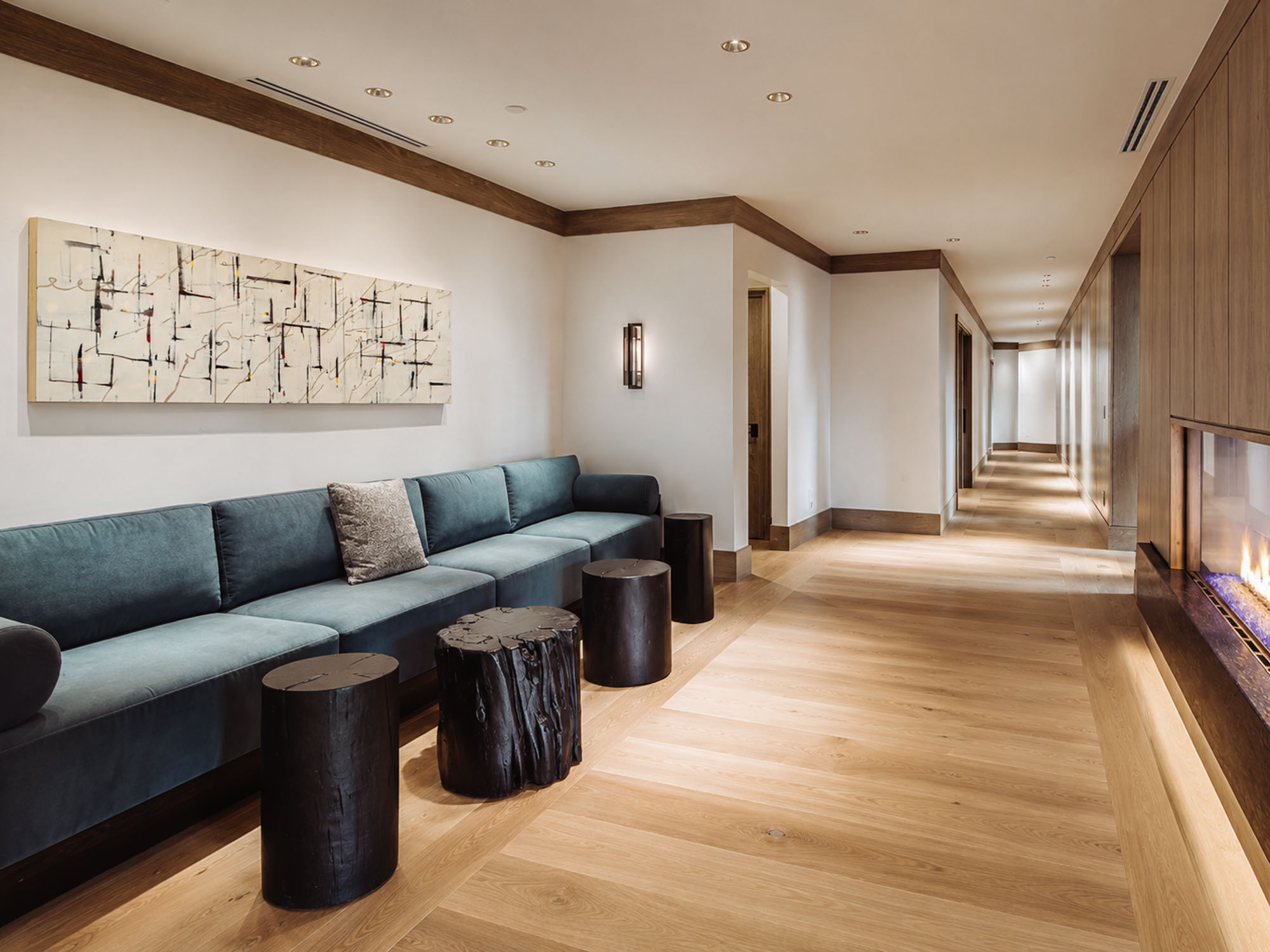 Montage Spanish Peaks residence — fireside corridor lounge with long abstract canvas